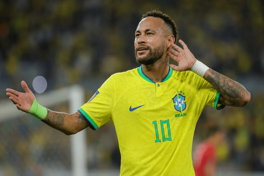 Jugador brasileño celebra un gol en un partido de futbol con la camiseta amarilla y verde